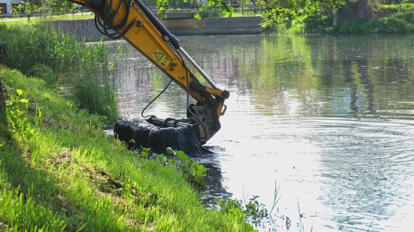 Dredging a pond with an excavator